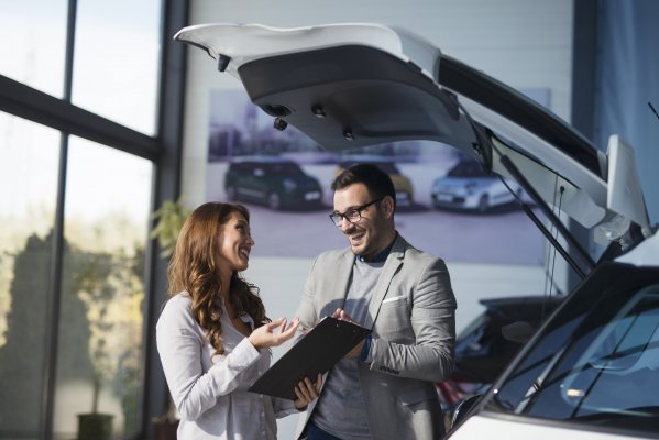 usaa extended car warranty woman signing car warranty held by happy man with glasses